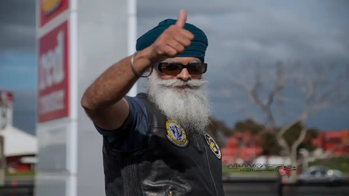 Sikh man Ravi Singh with turban giving thumbs up in Khalsa Aid vest.