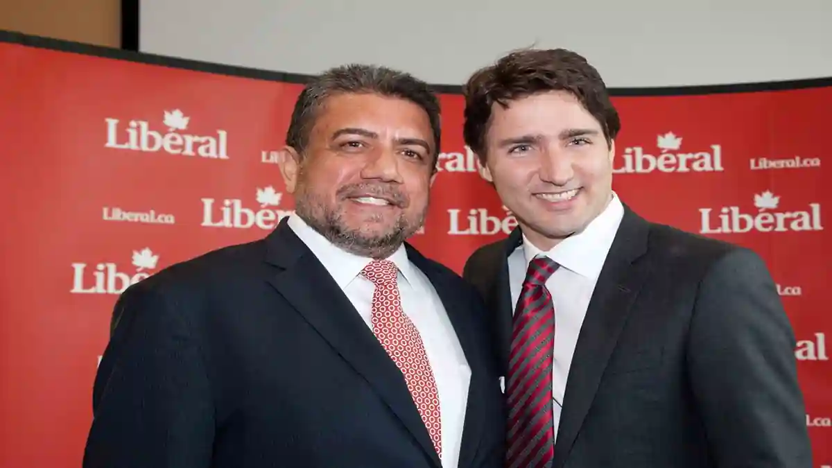 MP Sukh Dhaliwal with Justin Trudea speaking at a podium.